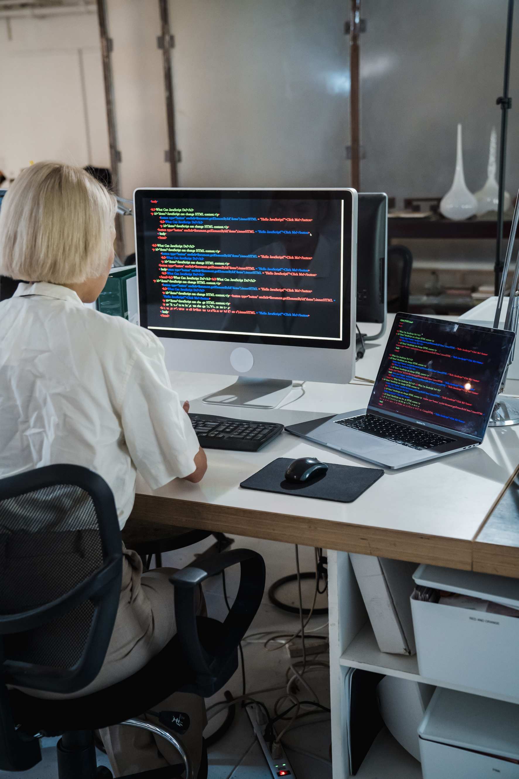 Developer workspace with laptop showing diagnostic tools, developer software office